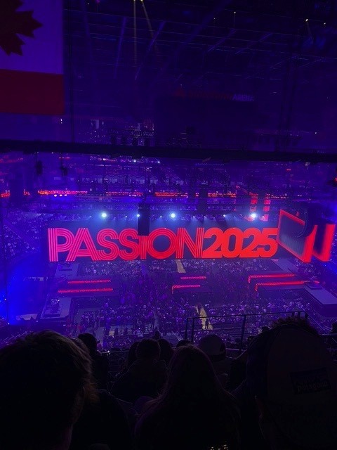 The Passion 2025 stage at State Farm Arena lit up in red with thousands of college-age students in the crowd